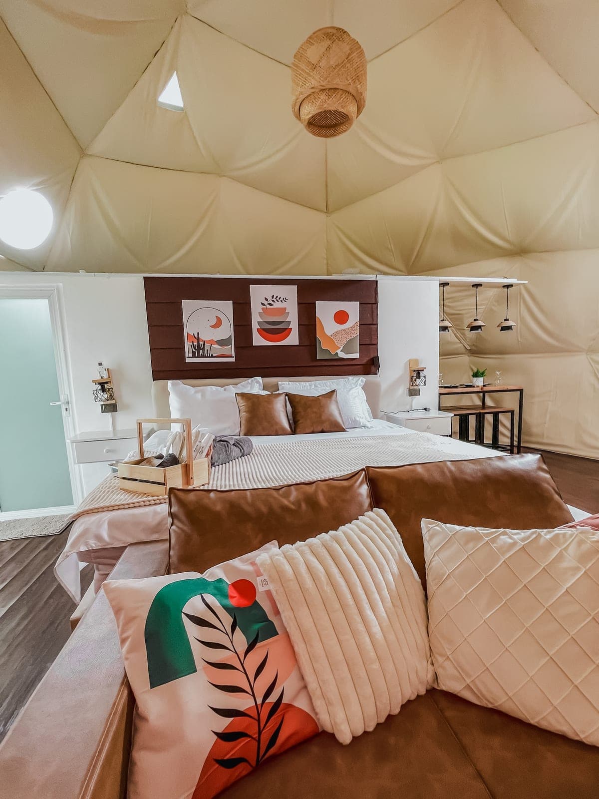 Dome 1: the king bed in soft earth tones beneath the dome canopy